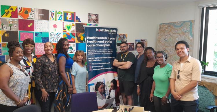 smiling group of people standing in front of Healthwatch banner