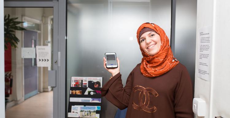 Woman holding phone woman with headscarf holding phone in hospital