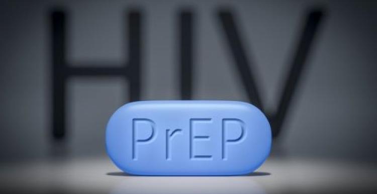 large blue pill with PrEP written on it, HIV written and blurred at the back