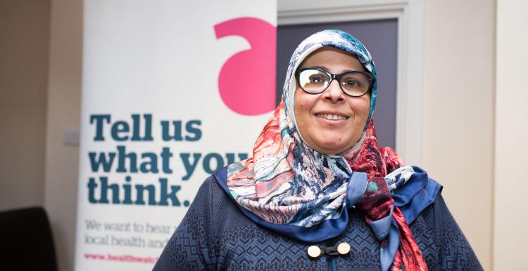 woman with headscarf in front of healthwatch banner