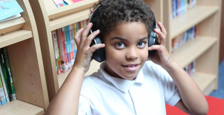 young boy with headphones listening to audiobook