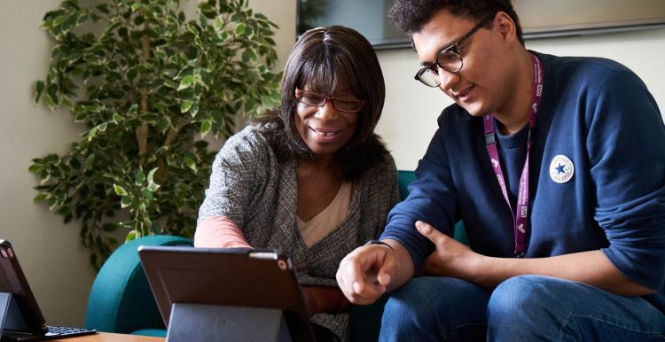 two people around a tablet device