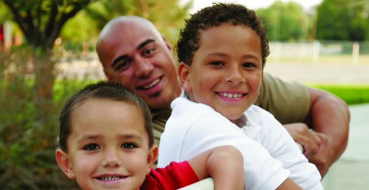 Man smiling with his two young children Man smiling with his two young children