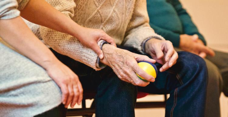 occupational therapy man squeezing ball with nurse