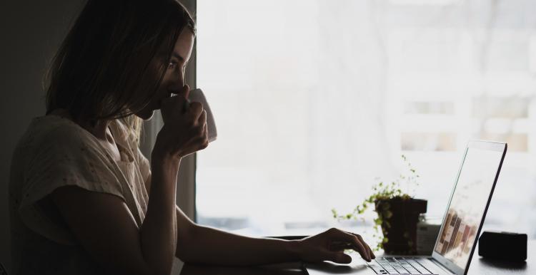 adult on computer coffee cup