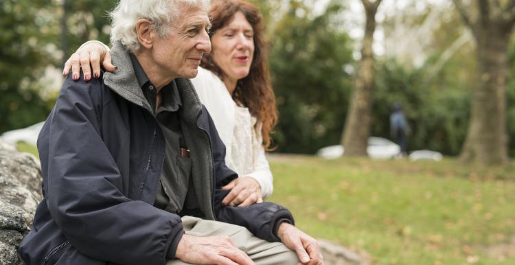 Elderly person sitting on a bench with a friend. Elderly person sitting on a bench with a friend.