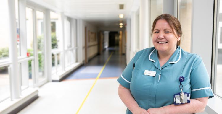 Nurse standing in hospital corridor in scrubs