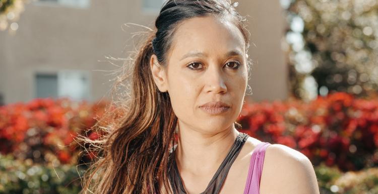 Mental Health Services Woman standing outside looking into the camera with a serious expression