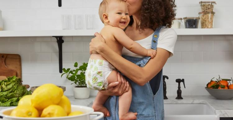 Mother holding smiling baby in nappy Mother holding smiling baby in nappy