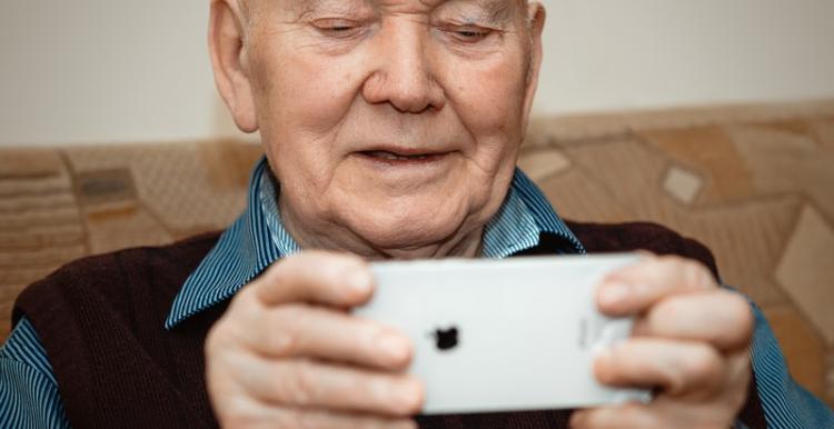 Image of older man holding iphone