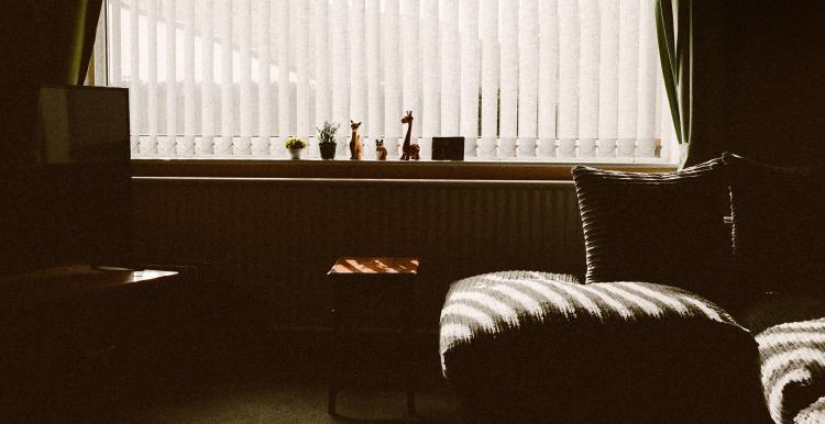 sofa besides window in dimly lit flat