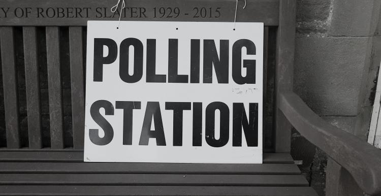 Polling station sign on bench