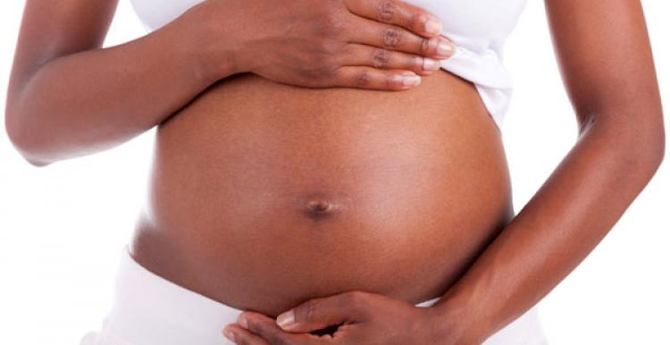 close up of hands holding pregnant stomach