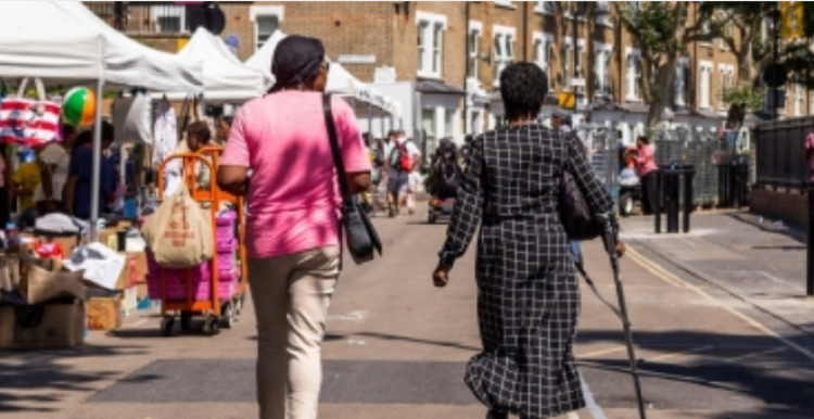 The back of two ladies walking in east street market