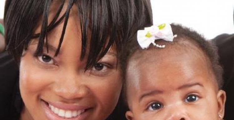 Close up of woman and her baby smiling at the camera