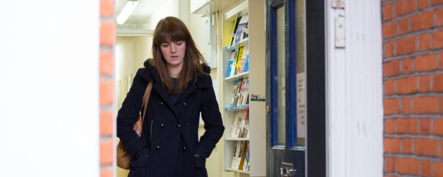 Woman alone walking out of the door looking down