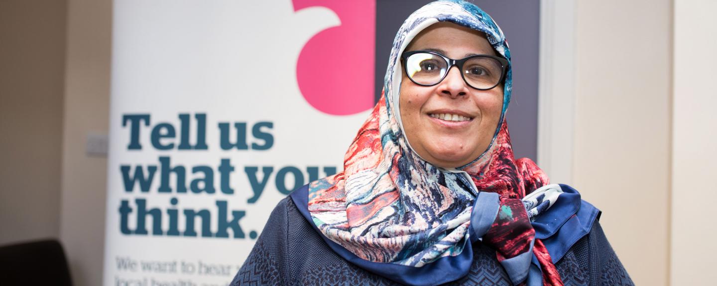 woman with headscarf in front of healthwatch banner