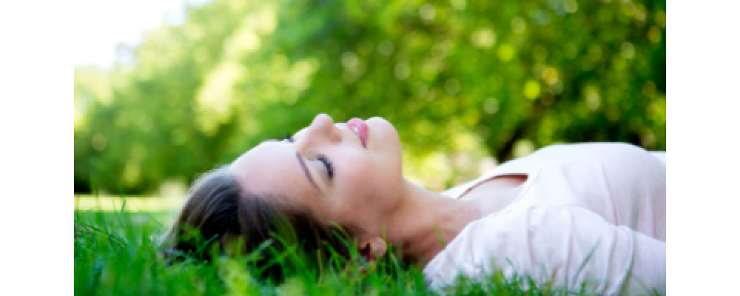 Woman lying down on grass smiling 