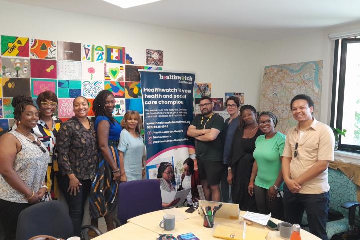 smiling group of people standing in front of Healthwatch banner