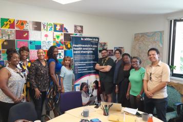 smiling group of people standing in front of Healthwatch banner