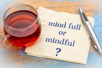 cup of tea, notes with Mindful or Mind Full?, silver pen next to it