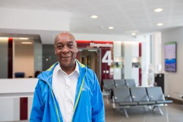 Man standing in hospital in front of Diagnostics sign