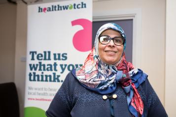 woman with headscarf in front of healthwatch banner