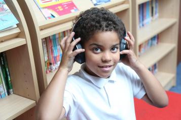 young boy with headphones listening to audiobook