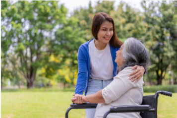 Woman hugging a woman in a wheelchair