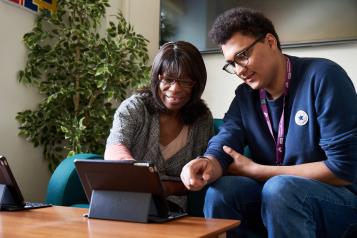 two people around a tablet device