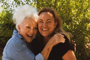 older women hugging and laughing