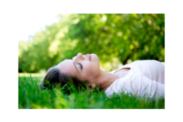 Woman lying down on grass smiling 