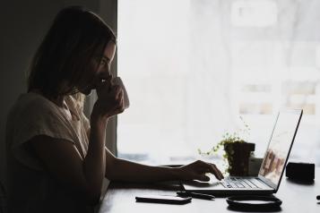 adult on computer coffee cup