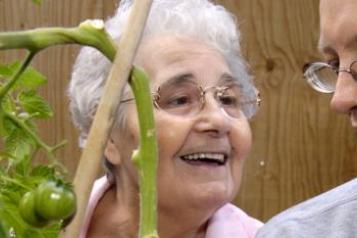 Old lady smiling with a young man with glasses