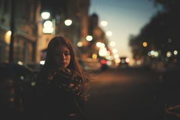 Young woman alone on a street in the dark 