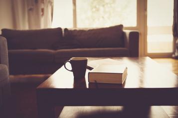 cup and book on top of coffee table
