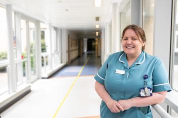 Nurse standing in hospital corridor in scrubs