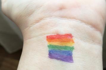 wrist with rainbow colours drawn on