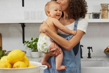 Mother holding smiling baby in nappy