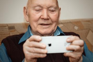 Image of older man holding iphone