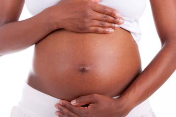 close up of hands holding pregnant stomach