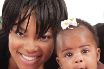 Close up of woman and her baby smiling at the camera