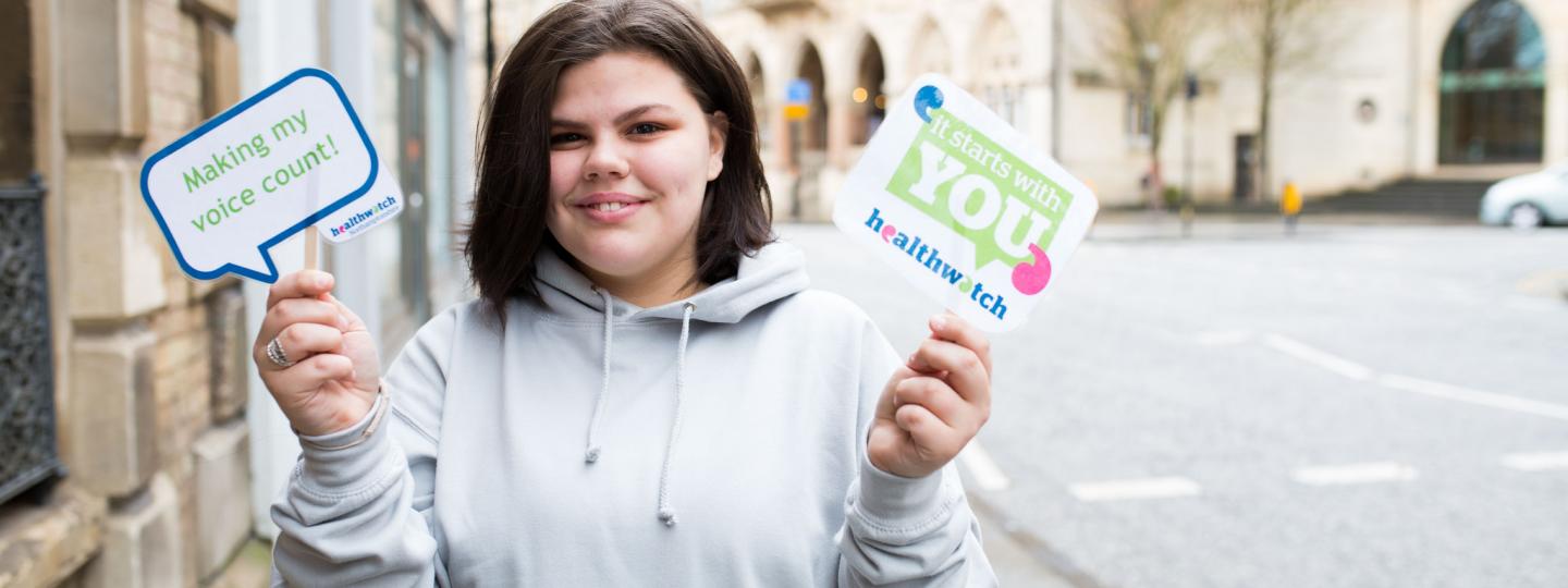 Healthwatch volunteer at a community event speaking to the public