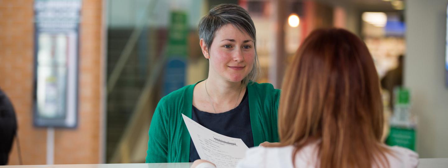 woman speaking to receptionist