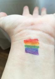 wrist with rainbow colours drawn on
